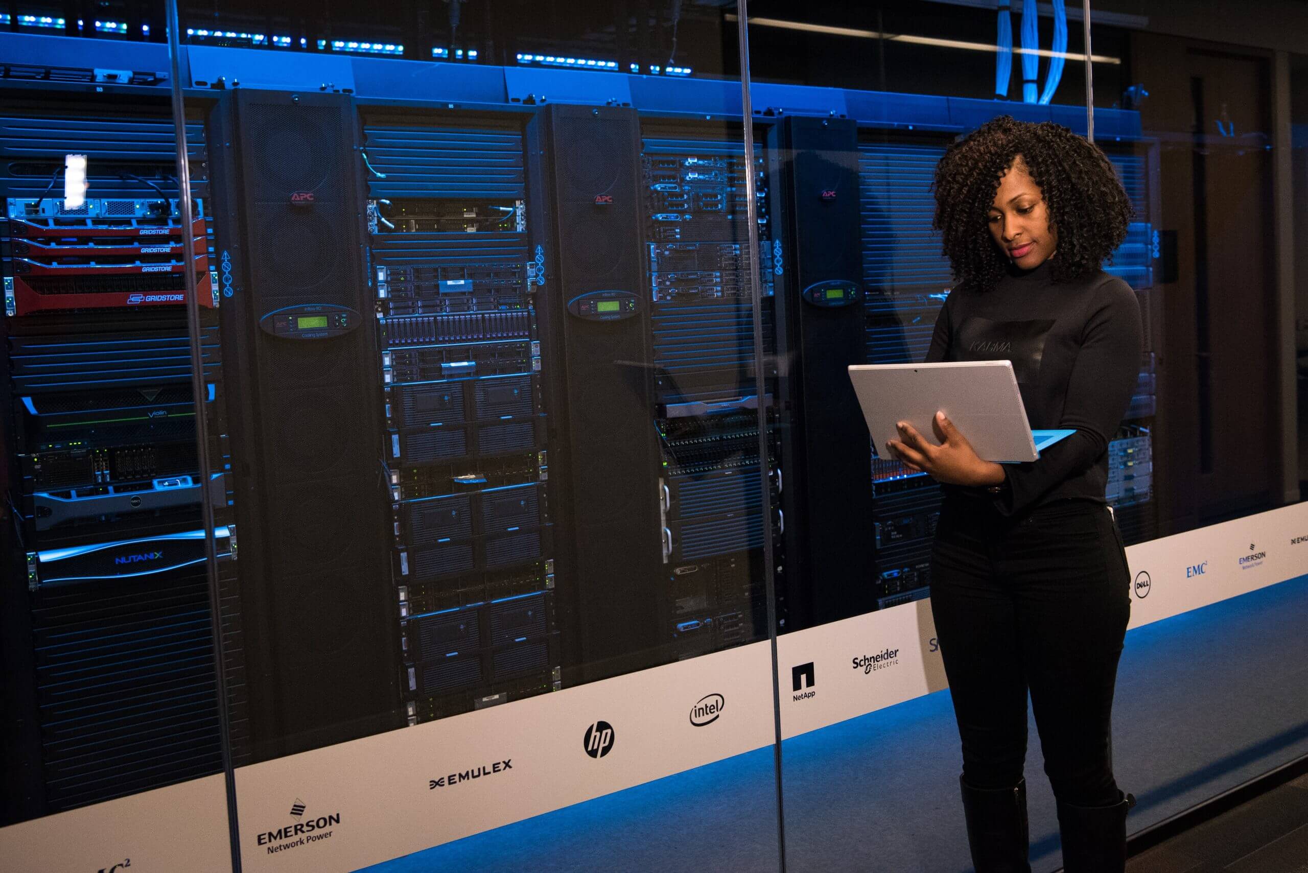 IT-support-woman-standing-while-carrying-laptop-in-a-data-center
